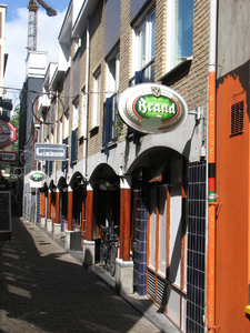 819437 Gezicht op de arcade met winkels en café's aan de noordzijde van de Zakkendragerssteeg te Utrecht.